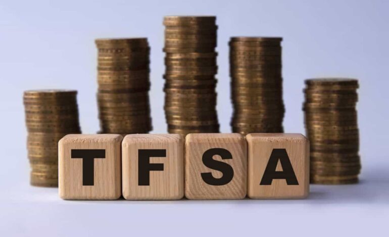 TFSA (Tax free savings account) acronym on wooden cubes on the background of stacks of coins